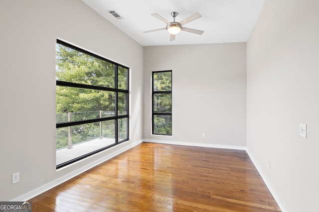 empty room featuring lofted ceiling, ceiling fan, and hardwood / wood-style flooring