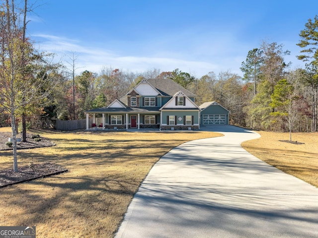 view of front of house featuring an outbuilding, a front lawn, a porch, and a garage