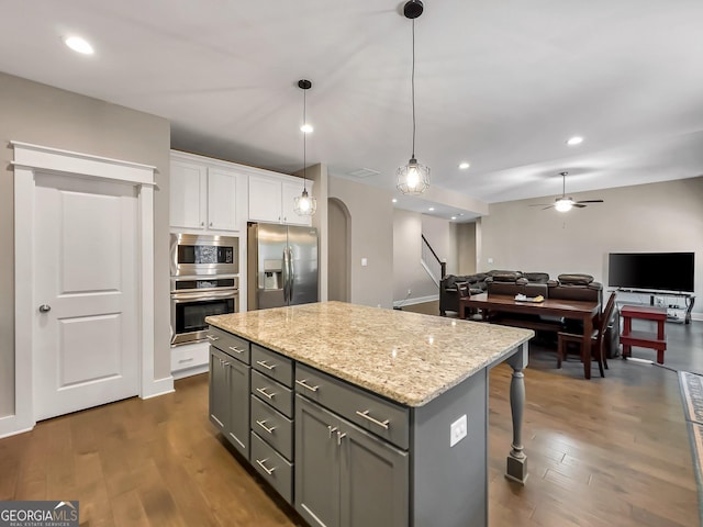 kitchen with decorative light fixtures, a kitchen island, dark hardwood / wood-style floors, and stainless steel appliances