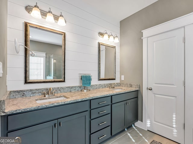 bathroom with tile patterned floors, wooden walls, and vanity