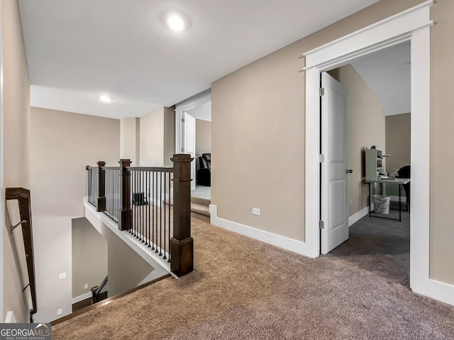 hallway featuring dark colored carpet