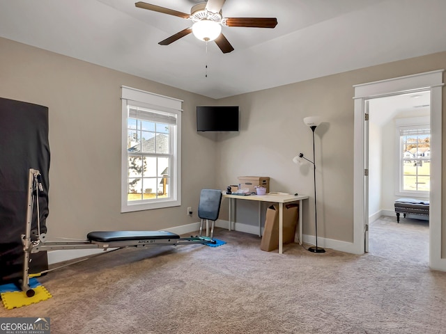 workout area with ceiling fan and light carpet