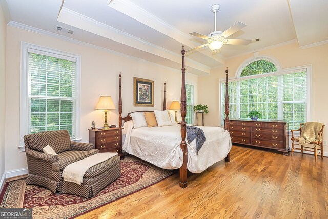 bedroom featuring ceiling fan, hardwood / wood-style flooring, crown molding, and multiple windows