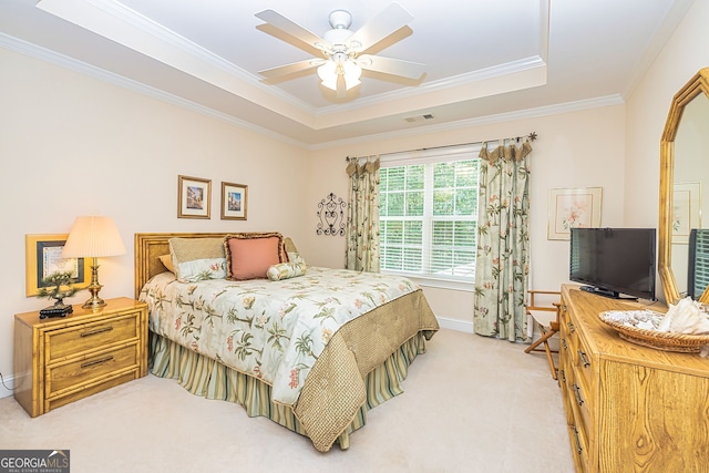 carpeted bedroom featuring crown molding, ceiling fan, and a raised ceiling