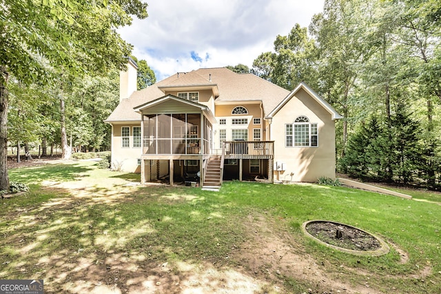 back of house featuring a sunroom, a deck, and a yard