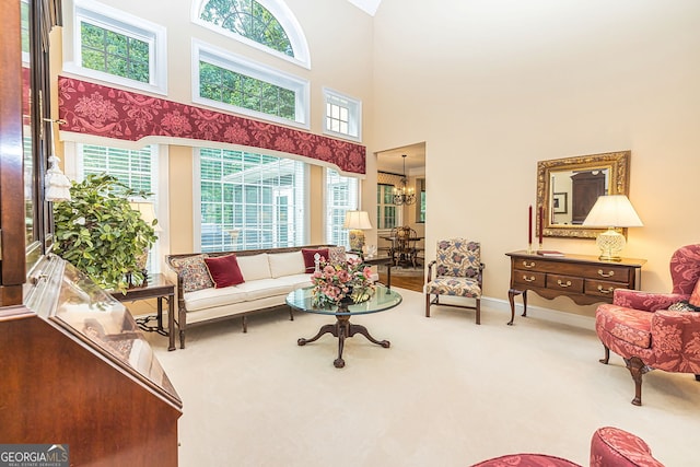 carpeted living room with a notable chandelier and a high ceiling