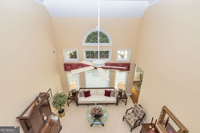 living room featuring ornamental molding, a high ceiling, ceiling fan, and hardwood / wood-style flooring