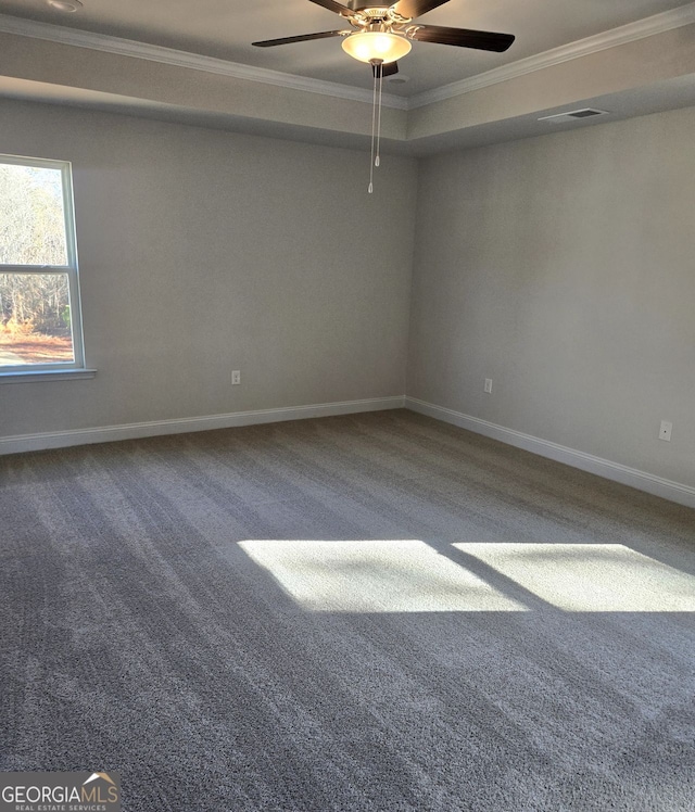 empty room with baseboards, carpet floors, visible vents, and crown molding