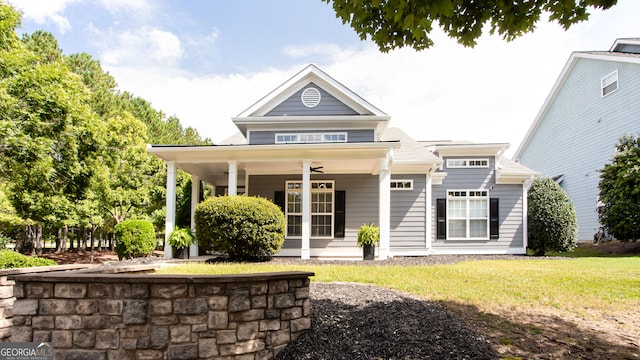 back of house with ceiling fan, a yard, and covered porch