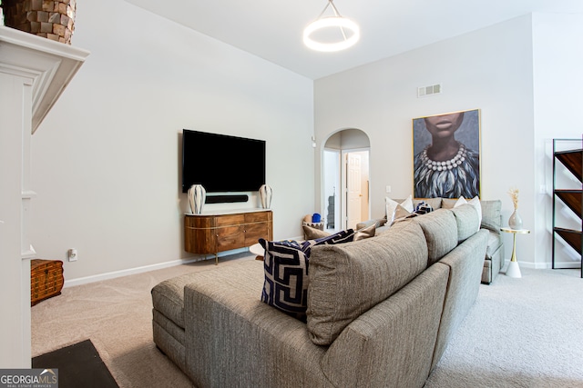 carpeted living room with a high ceiling