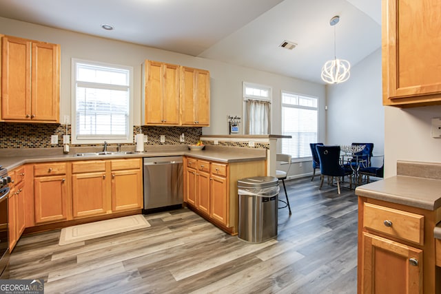 kitchen with decorative light fixtures, stainless steel appliances, light hardwood / wood-style floors, and tasteful backsplash