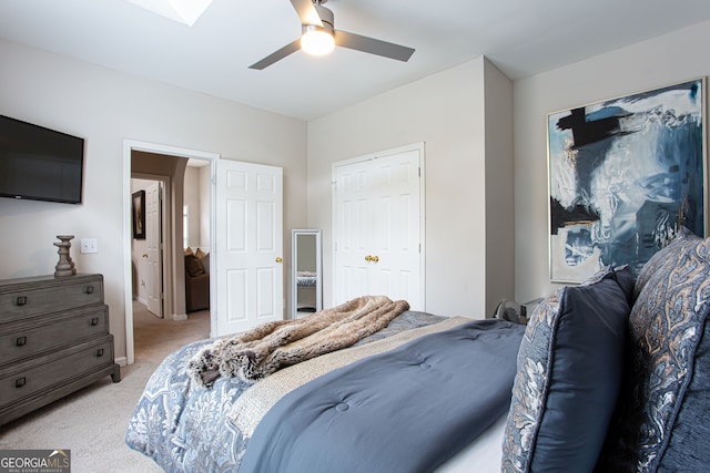 bedroom featuring ceiling fan, light colored carpet, and a closet