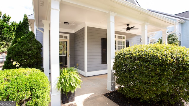 view of exterior entry with ceiling fan and a porch