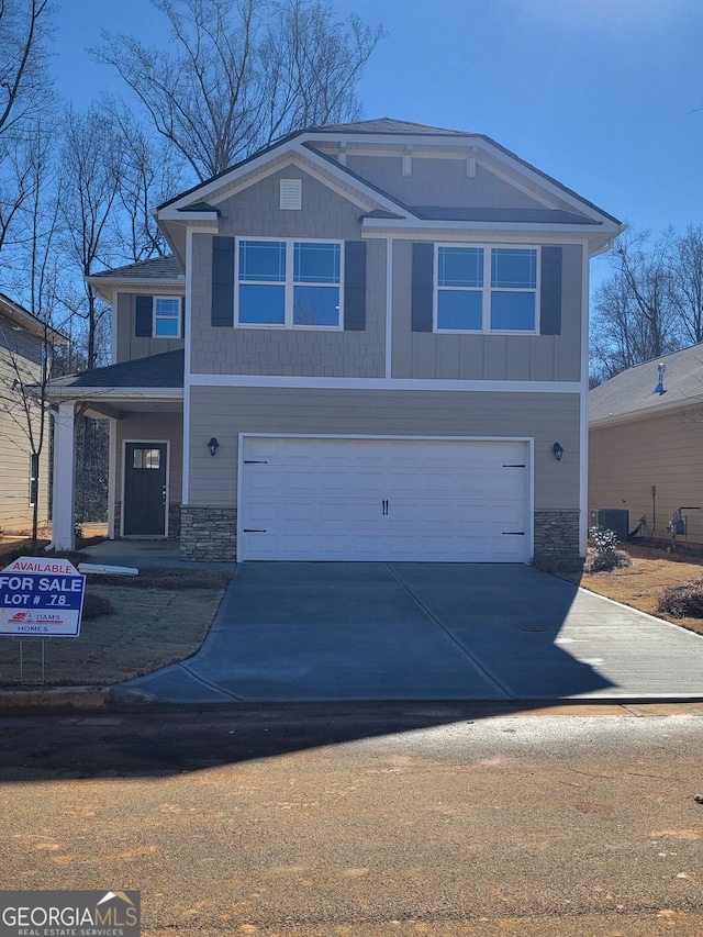 view of front of home with stone siding, an attached garage, and concrete driveway