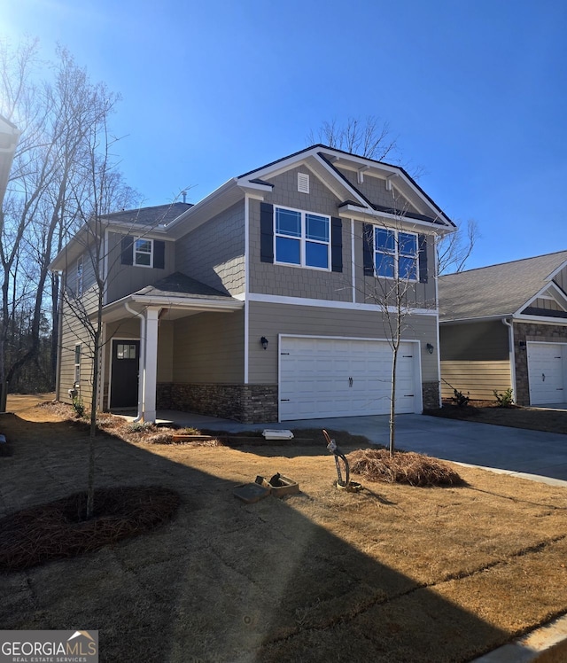 view of front of home featuring an attached garage, stone siding, and concrete driveway