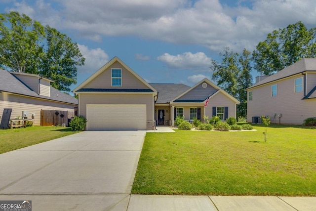 view of front of property featuring a front yard, a garage, and central AC