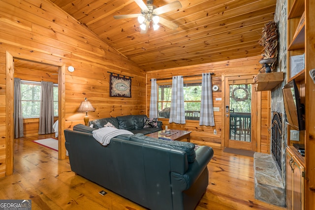 living room featuring light wood-type flooring, lofted ceiling, ceiling fan, and a healthy amount of sunlight