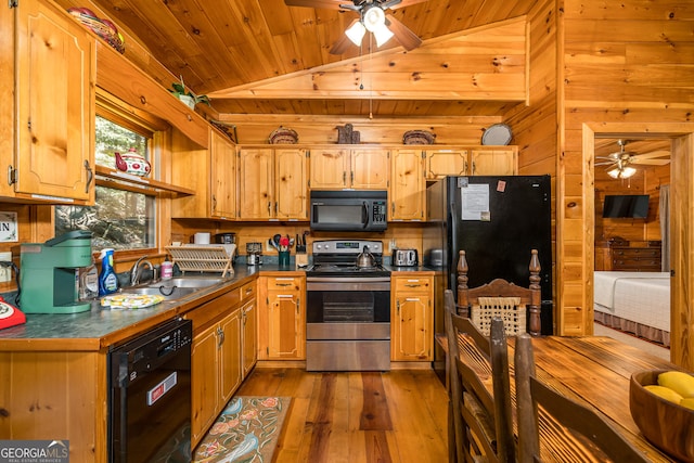 kitchen with vaulted ceiling, light wood-type flooring, black appliances, ceiling fan, and sink