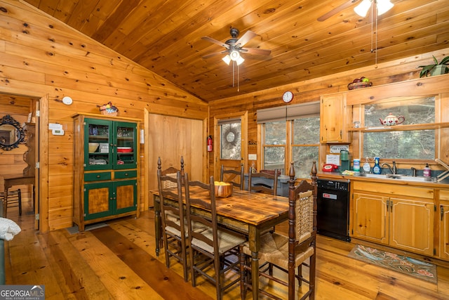 dining space featuring ceiling fan, wooden walls, and light hardwood / wood-style floors