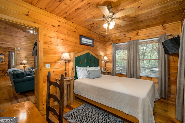 bedroom featuring wood ceiling, light hardwood / wood-style floors, vaulted ceiling, wood walls, and ceiling fan