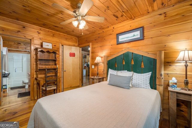 bedroom featuring ceiling fan, wood ceiling, connected bathroom, wood walls, and hardwood / wood-style flooring