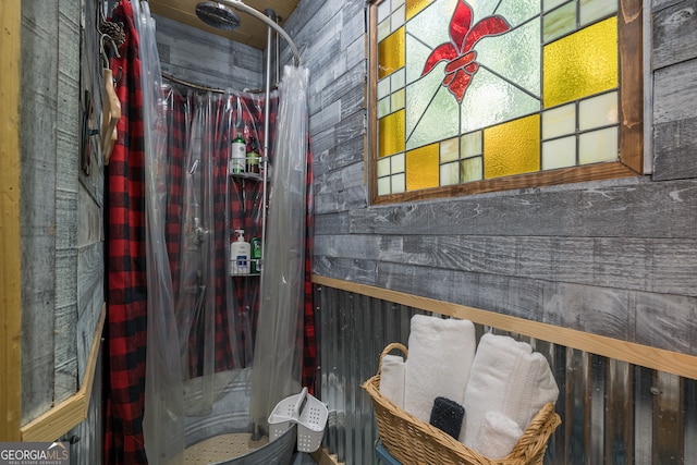 bathroom featuring wooden walls and curtained shower