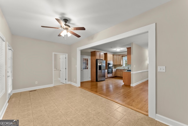 unfurnished living room with light wood-type flooring and ceiling fan