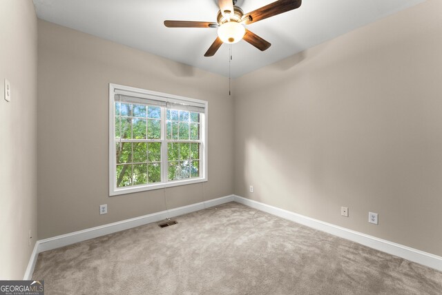 spare room featuring carpet and ceiling fan