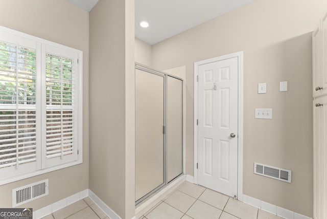 bathroom with tile patterned flooring and a shower with door