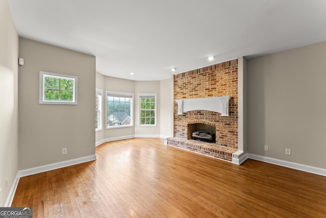 unfurnished living room with a fireplace and hardwood / wood-style floors