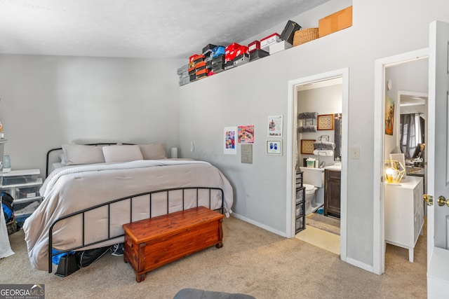 bedroom with light carpet, lofted ceiling, and ensuite bath