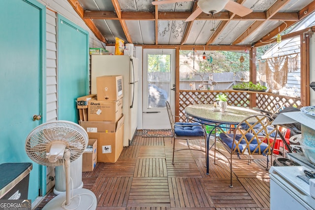 sunroom featuring lofted ceiling with beams and ceiling fan