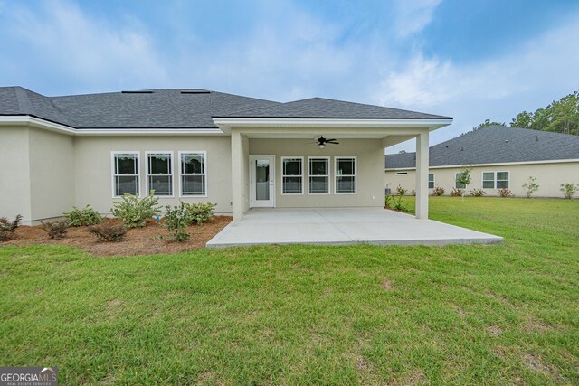 back of house featuring ceiling fan, a lawn, and a patio