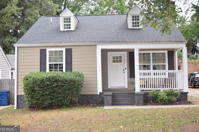 new england style home featuring a front lawn and covered porch