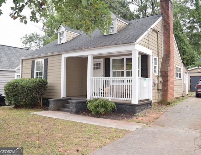 cape cod house featuring a front yard and covered porch