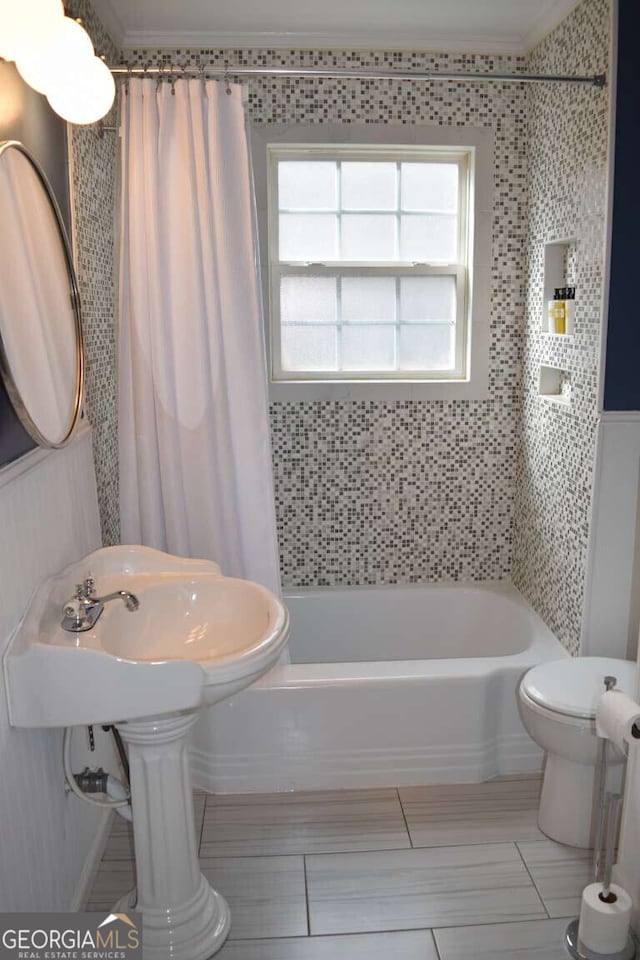 bathroom featuring shower / bath combination with curtain, crown molding, and toilet