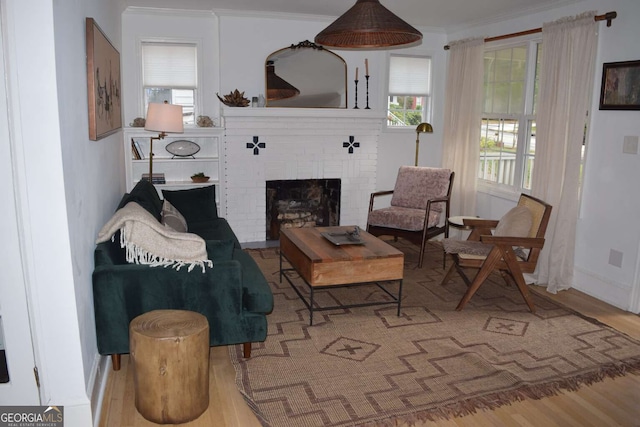 living room with ornamental molding, hardwood / wood-style flooring, and a fireplace