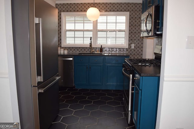 kitchen with appliances with stainless steel finishes, decorative backsplash, sink, and blue cabinetry