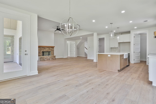 kitchen featuring hanging light fixtures, white cabinets, a spacious island, and light wood-type flooring