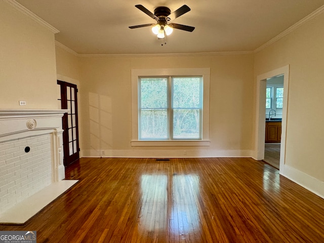 unfurnished living room featuring ornamental molding, dark wood-type flooring, ceiling fan, and a healthy amount of sunlight