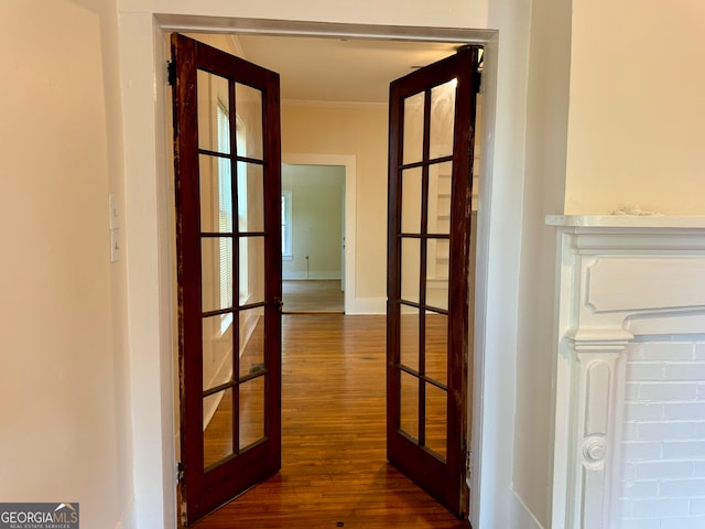 hallway with dark wood-type flooring, french doors, and crown molding