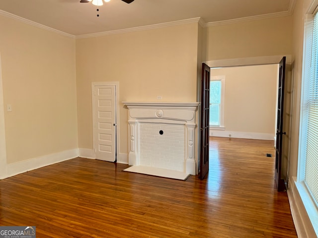 unfurnished living room featuring ceiling fan, dark hardwood / wood-style floors, crown molding, and a healthy amount of sunlight