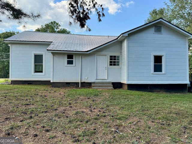 rear view of house featuring a yard