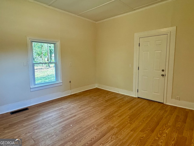 unfurnished room featuring ornamental molding and hardwood / wood-style floors