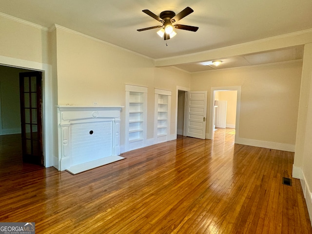 unfurnished living room with ornamental molding, built in shelves, ceiling fan, and hardwood / wood-style floors