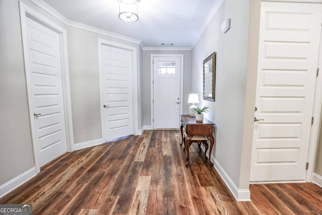 foyer entrance with ornamental molding and dark hardwood / wood-style flooring