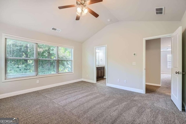 unfurnished bedroom featuring carpet, connected bathroom, lofted ceiling, and ceiling fan