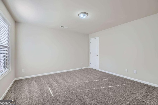 unfurnished room featuring carpet flooring and a healthy amount of sunlight