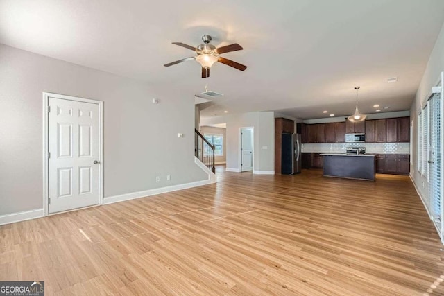 unfurnished living room with light wood-type flooring and ceiling fan