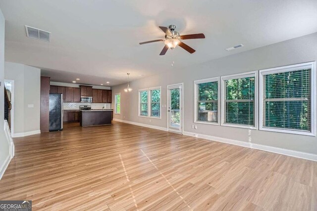 unfurnished living room featuring ceiling fan and light hardwood / wood-style flooring